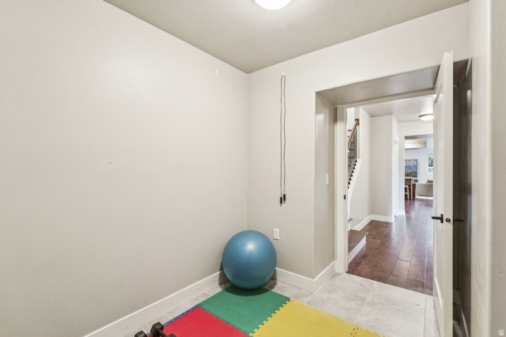 Exercise room with baseboards and light wood-style floors