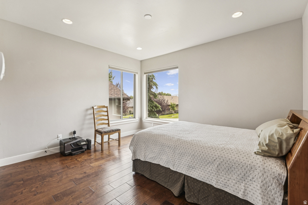 Bedroom with dark wood finished floors and recessed lighting