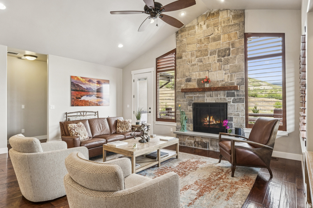 Living room featuring dark wood-type flooring, a fireplace, ceiling fan, lofted ceiling, and recessed lighting
