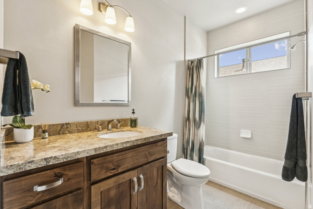 Bathroom featuring vanity, shower / bathtub combination with curtain, light tile patterned floors, and recessed lighting