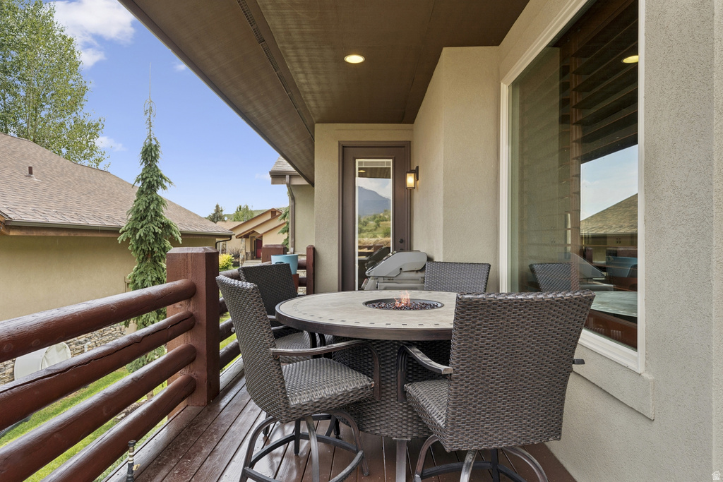 Balcony with outdoor dining area and an outdoor fire pit