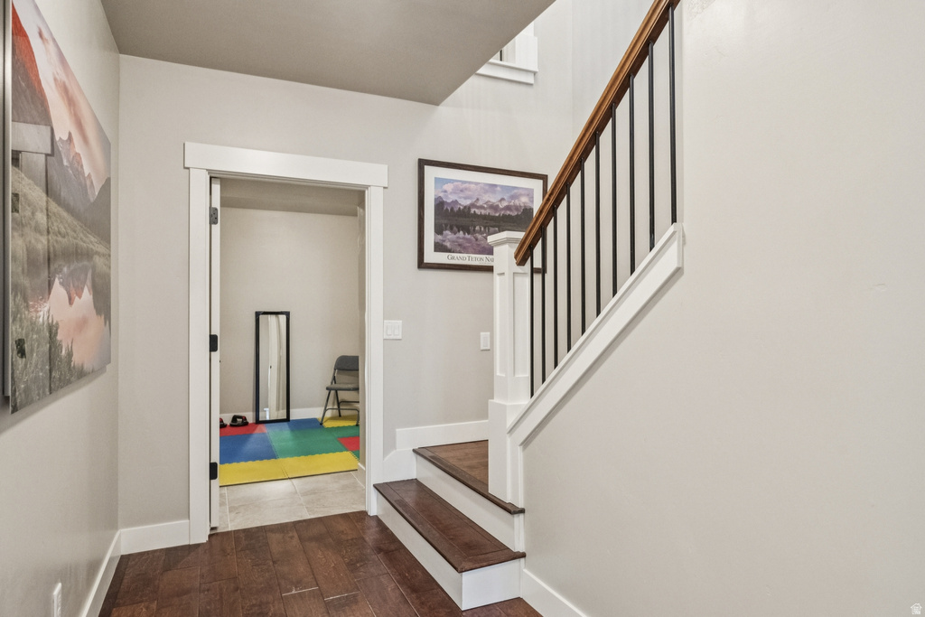 Stairs with wood finished floors and baseboards