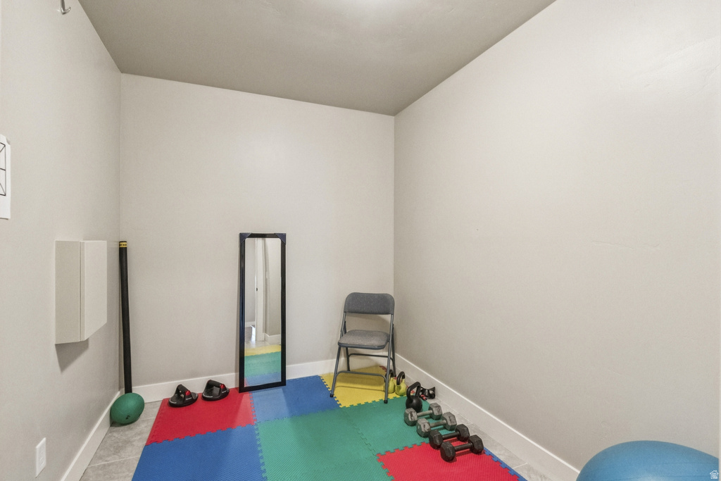 Workout area with baseboards and light tile patterned floors