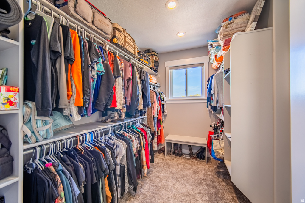 Walk in closet with light colored carpet