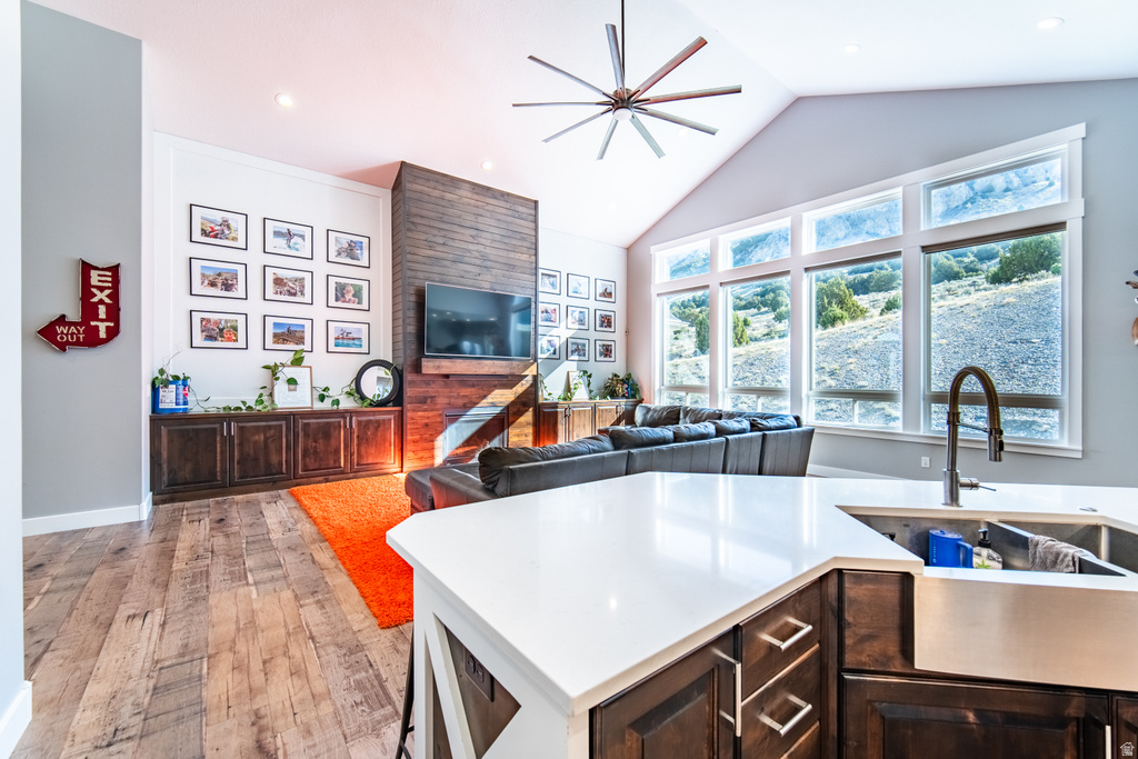 Kitchen featuring ceiling fan, dark wood finish cabinets, light wood-style flooring, open floor plan, and recessed lighting