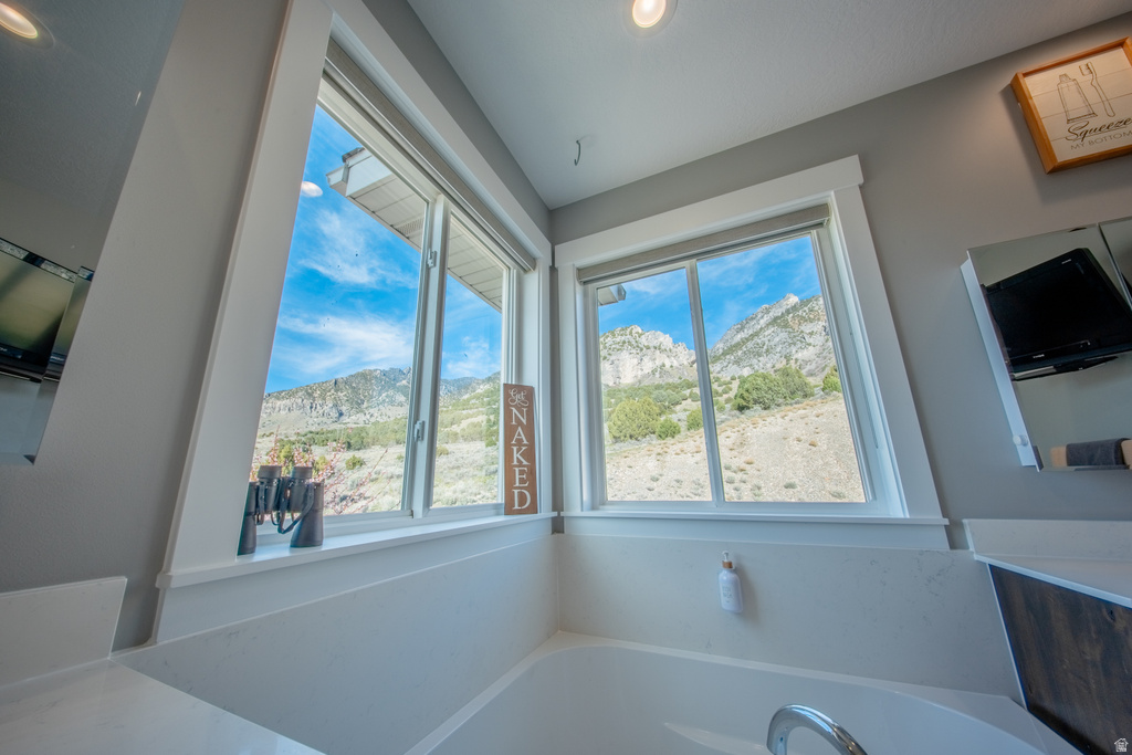 Bathroom with a mountain view and a bath