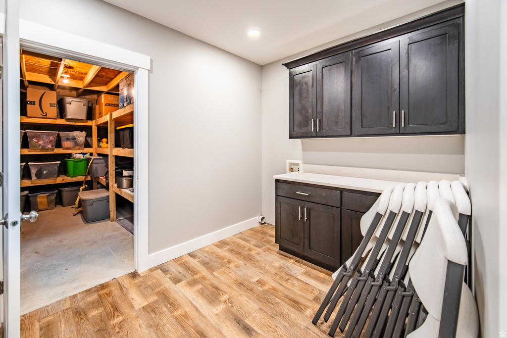 Laundry area with cabinet space, washer hookup, recessed lighting, and light wood-type flooring