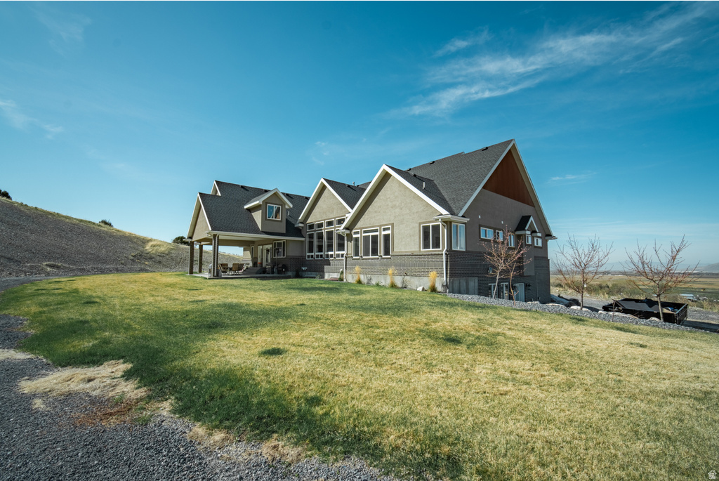 View of front facade featuring a front lawn and a patio area