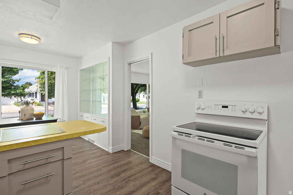 Kitchen featuring wood-finish flooring, white walls, and a built-in display cabinet with glass doors