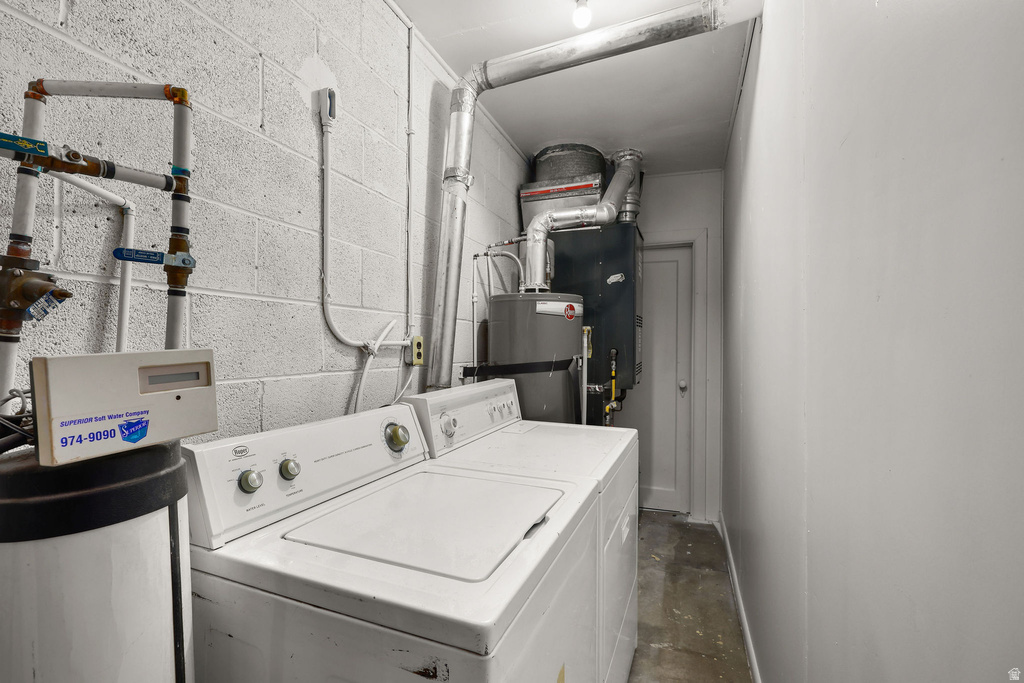 Utility space featuring a washer, dryer, water heater, furnace, and exposed piping