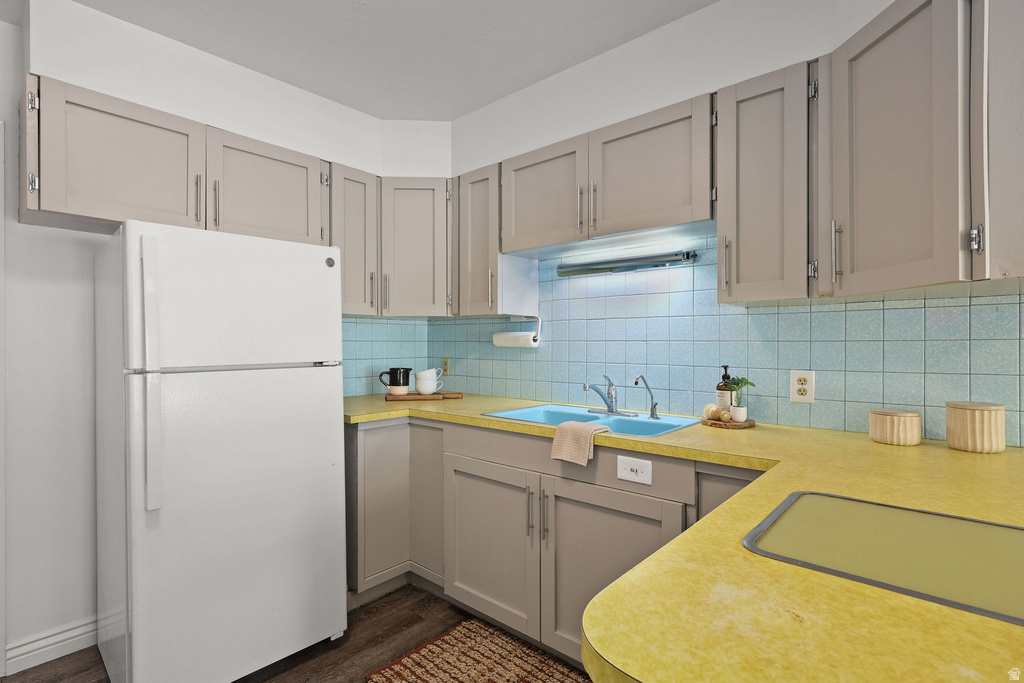 Kitchen featuring light gray cabinetry, yellow countertops, a blue tiled backsplash, and wood-finish flooring