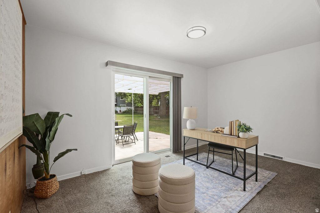Interior space featuring light gray walls, plush gray carpeting, and a modern flush-mount ceiling light