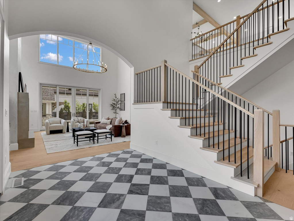 Foyer with suspended lighting, a high ceiling, and arched walkways