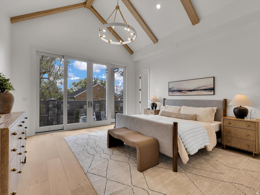 Bedroom featuring light wood-style floors, access to outside, lofted ceiling, and suspended lighting
