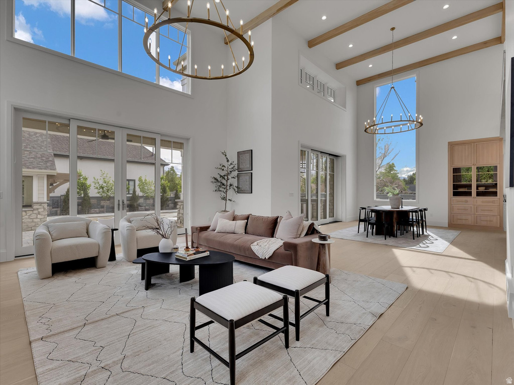 Living area featuring a chandelier, light wood-style floors, and plenty of natural light