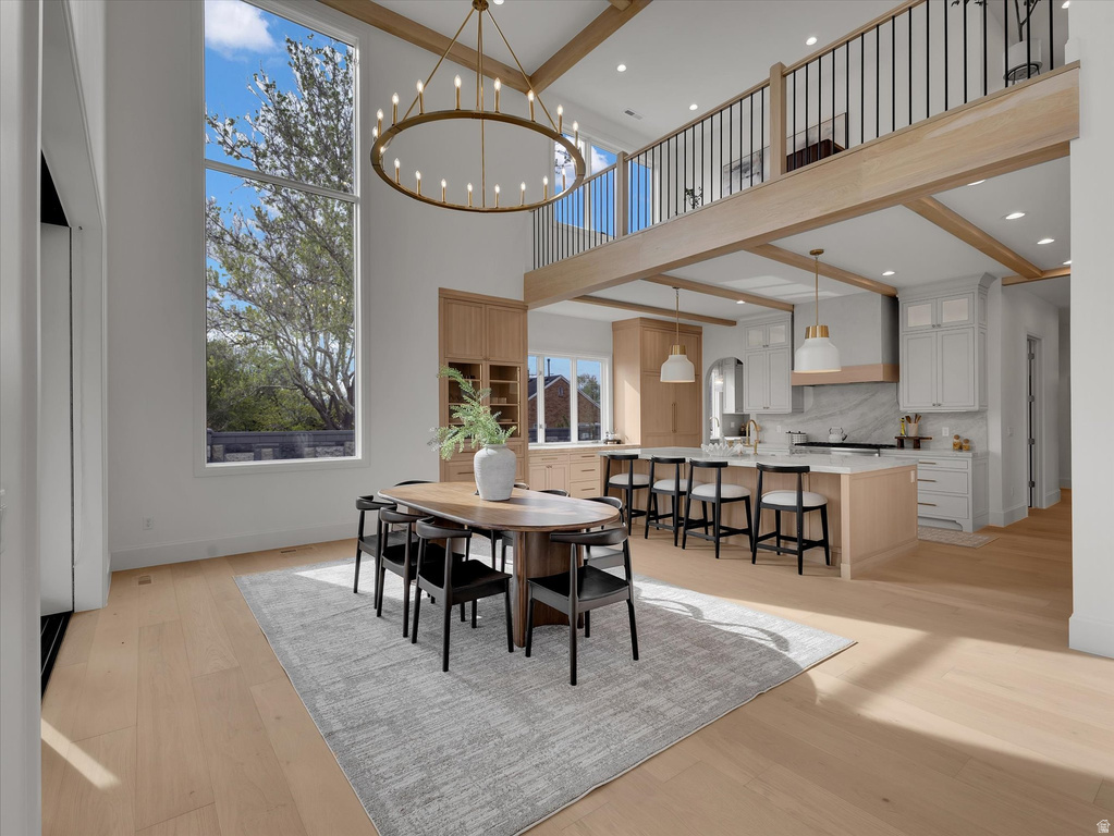 Dining area with light wood-style flooring and suspended lighting