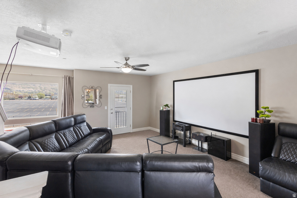 Cinema with light colored carpet and a ceiling fan