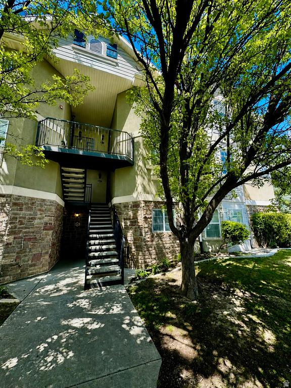 Multi-story building exterior featuring stone-finish siding, stucco, and horizontal siding
