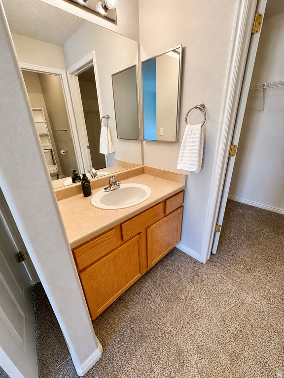 Bathroom vanity featuring a light-toned countertop with an integrated sink and chrome faucet