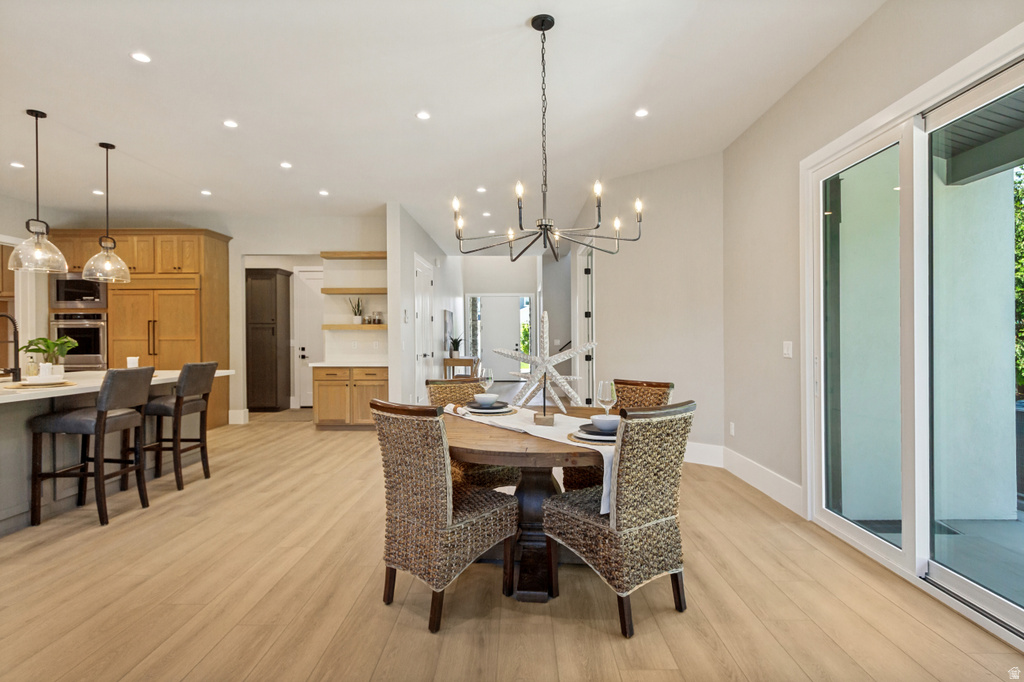 Open-concept living space featuring wood-finish flooring, recessed lighting, and a modern chandelier