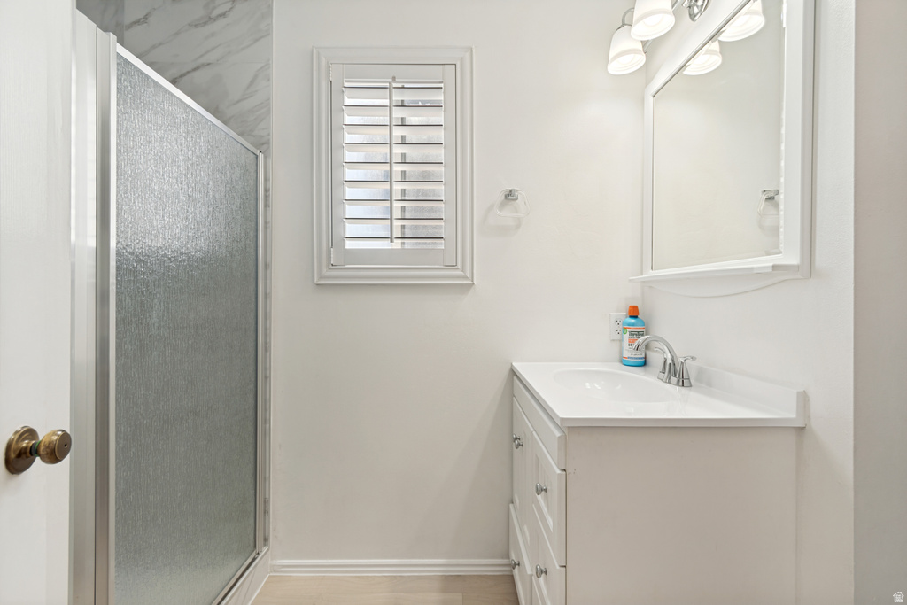 Bathroom featuring a white vanity with an integrated sink, polished chrome faucet, and mirrored medicine cabinet