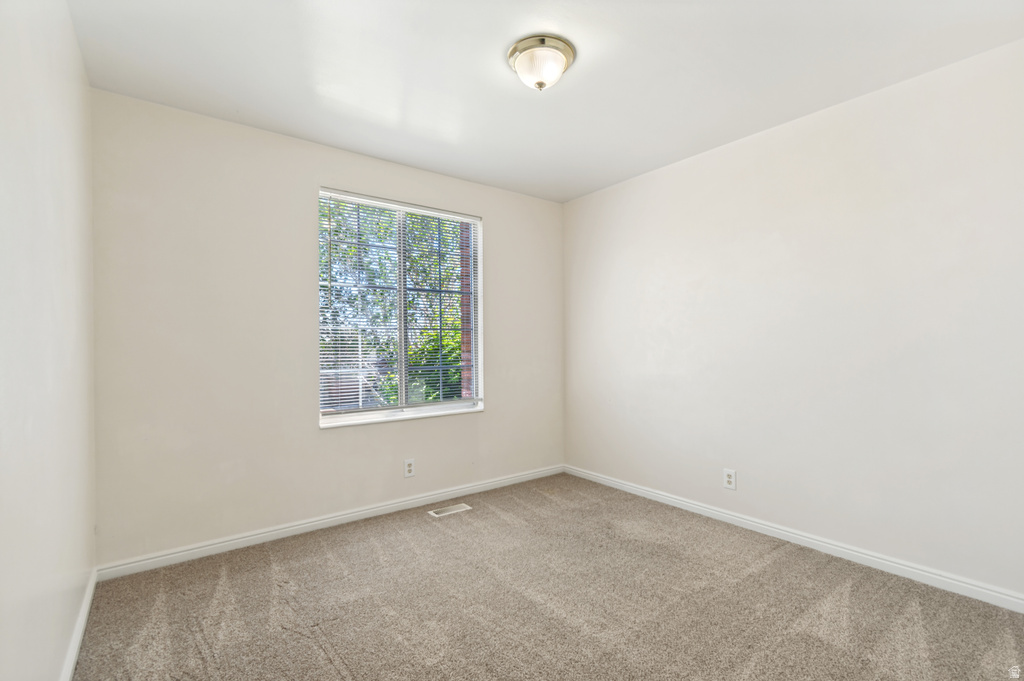 Bright room featuring neutral-toned walls and carpet flooring