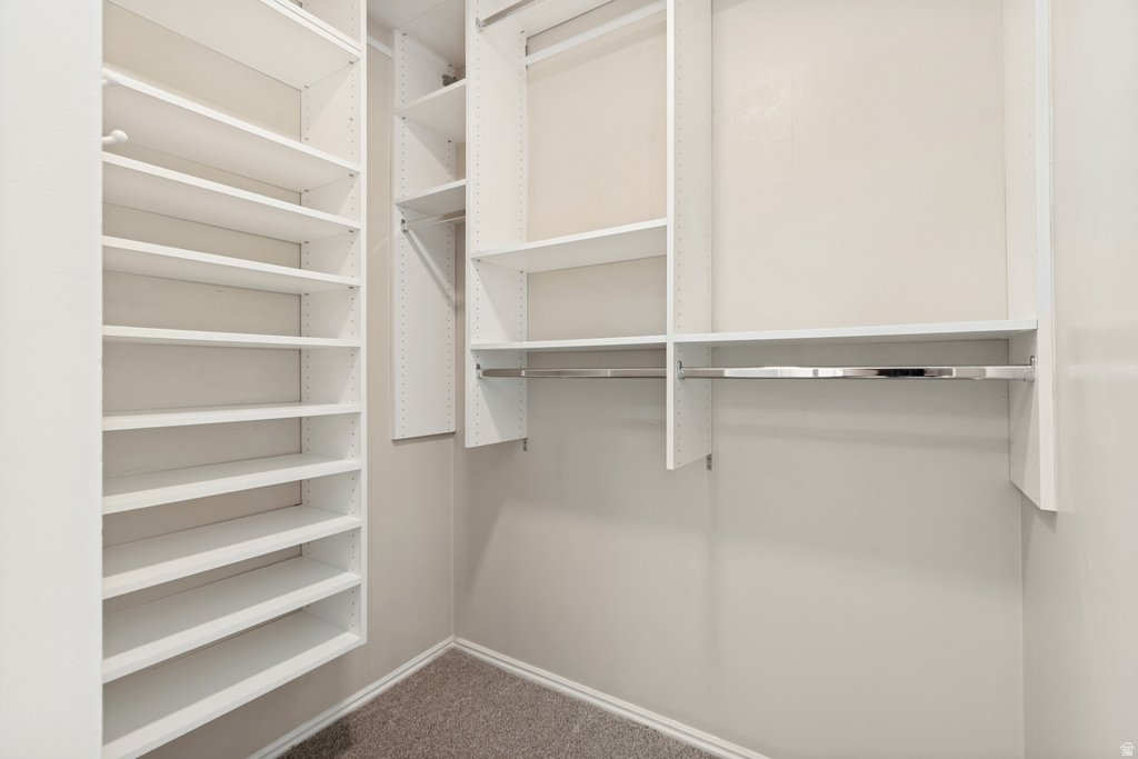 Custom closet system with multiple shelving units and chrome hanging rods