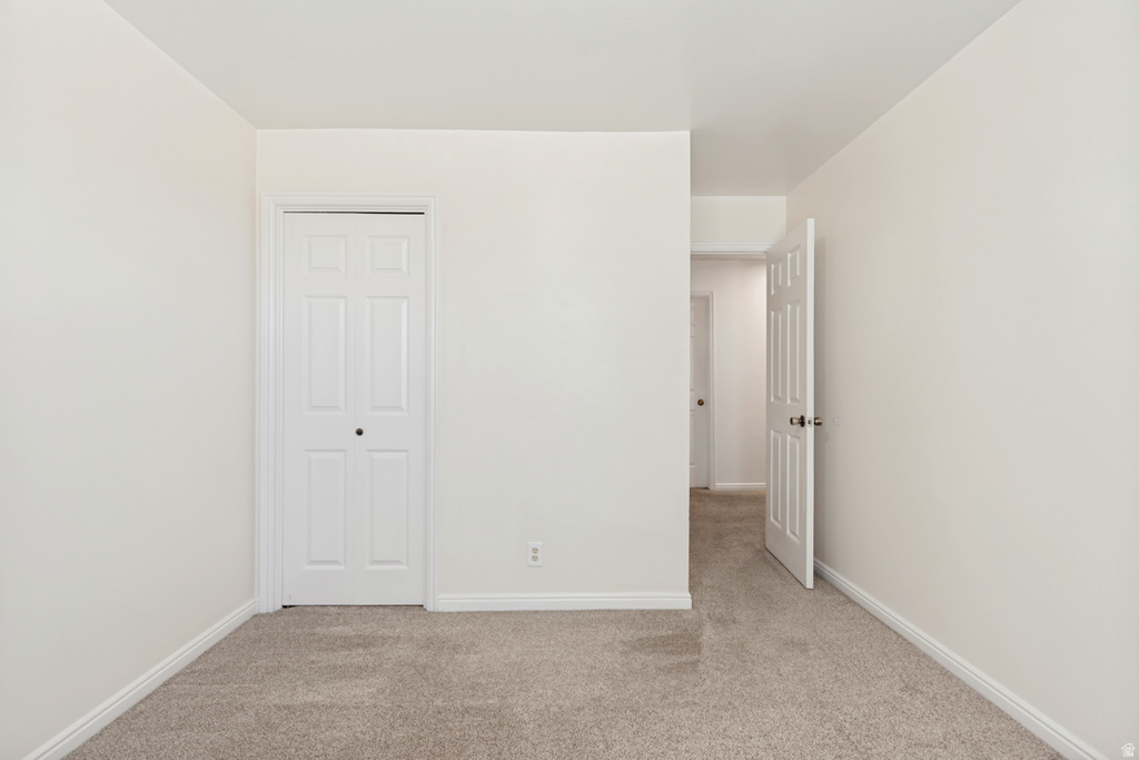 Neutral-toned interior room featuring light beige walls and complementing carpet flooring
