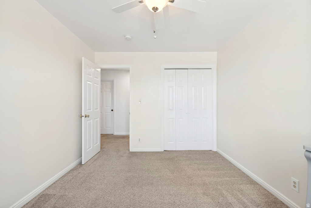 Neutral-toned room featuring light beige carpeting and white walls