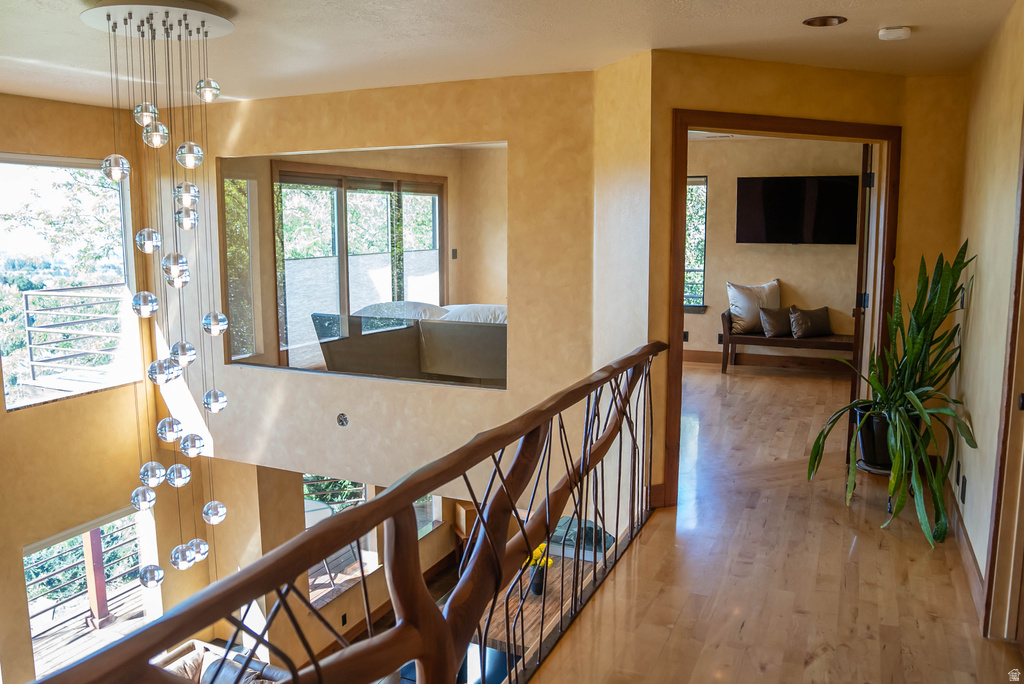 Open landing with wood-finish flooring and a custom wood and wrought iron railing