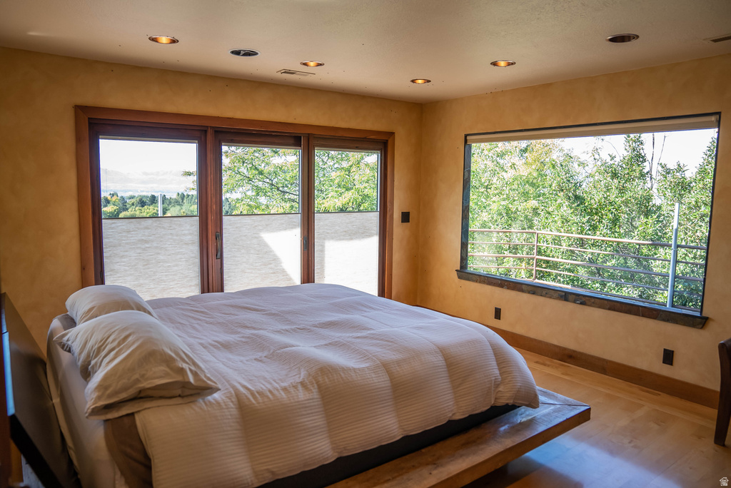 Spacious room with wood-finish flooring, recessed lighting, and expansive windows