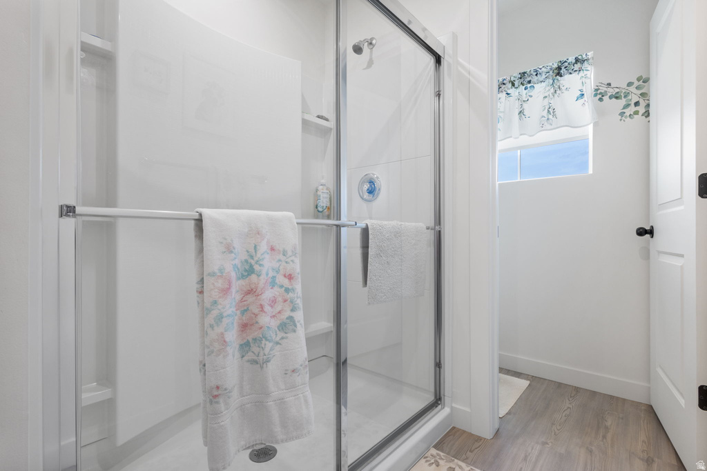 Bathroom featuring a shower stall and light wood-style flooring