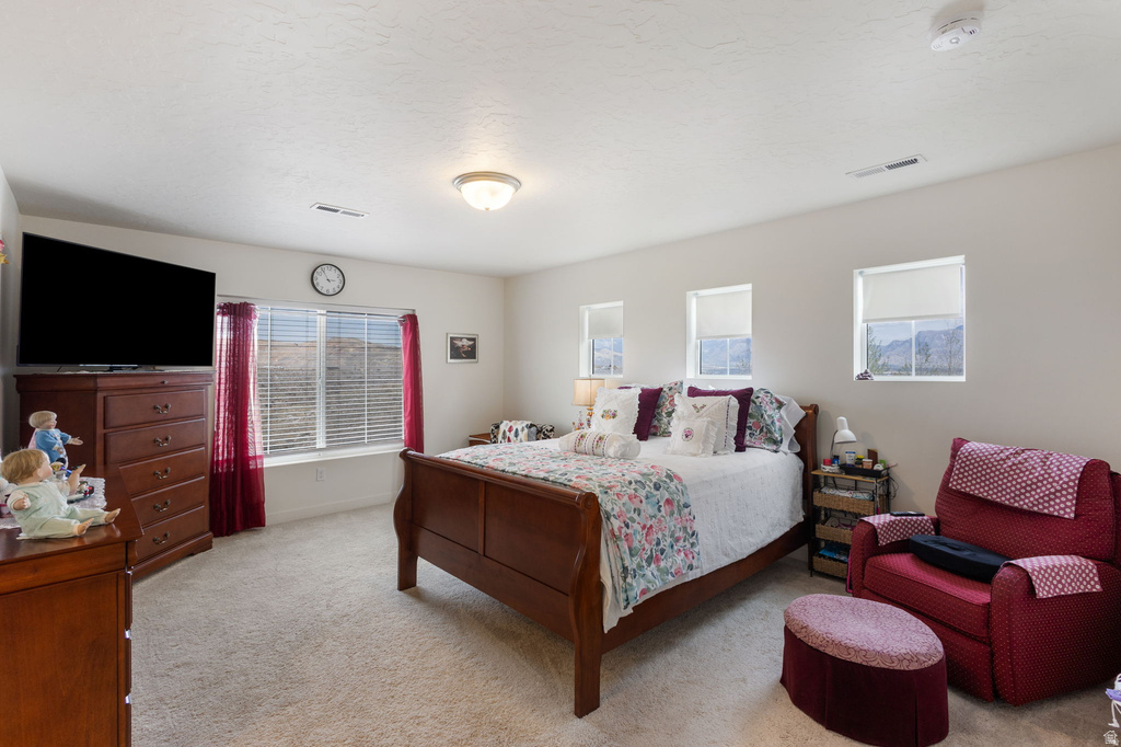 Bedroom featuring light colored carpet and baseboards