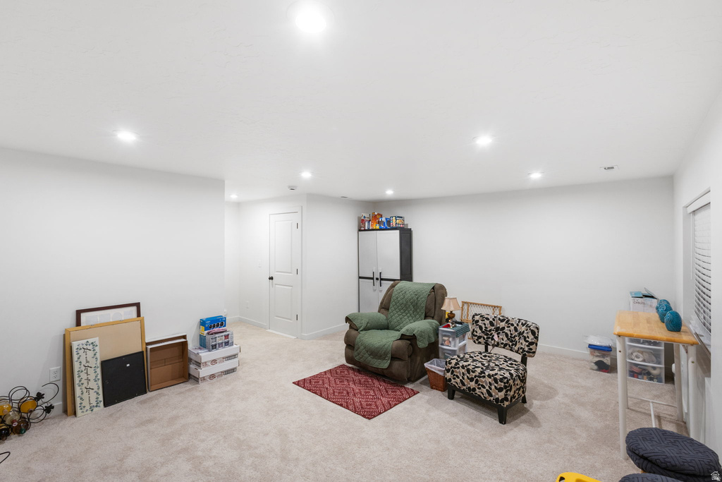 Living area with light colored carpet and recessed lighting