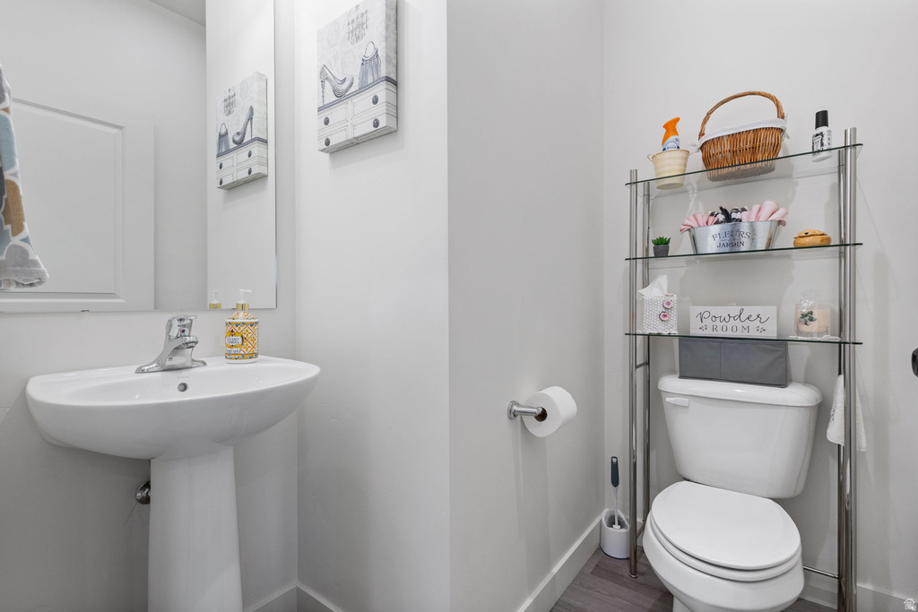 Bathroom with toilet and wood finished floors