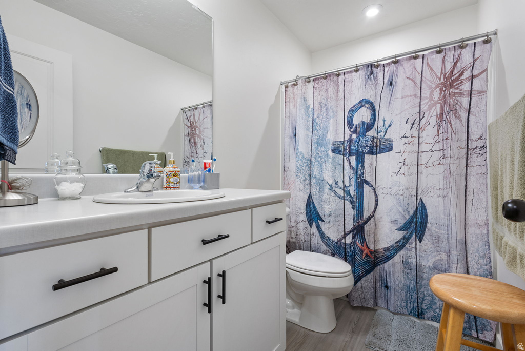 Bathroom with vanity, a shower with shower curtain, and light wood-style flooring
