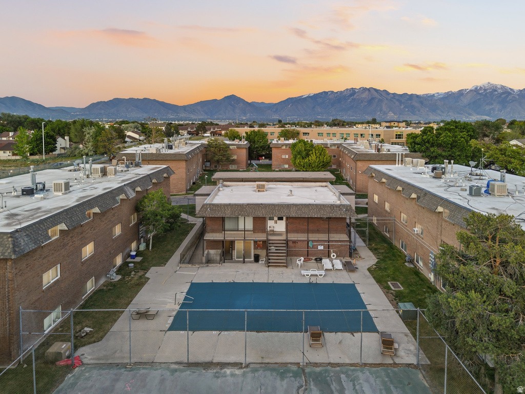 Central outdoor pool area with surrounding multi-story brick buildings, concrete patio, and fenced perimeter