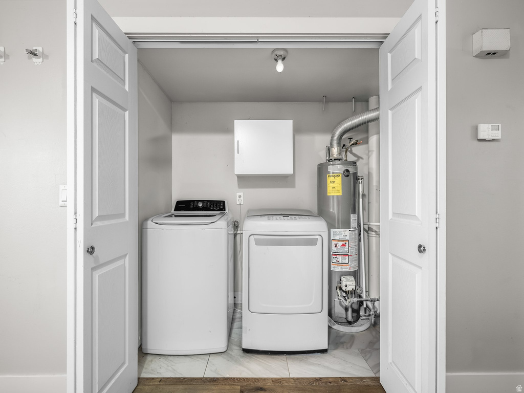Dedicated laundry closet featuring a top-load washing machine, front-load dryer, and water heater