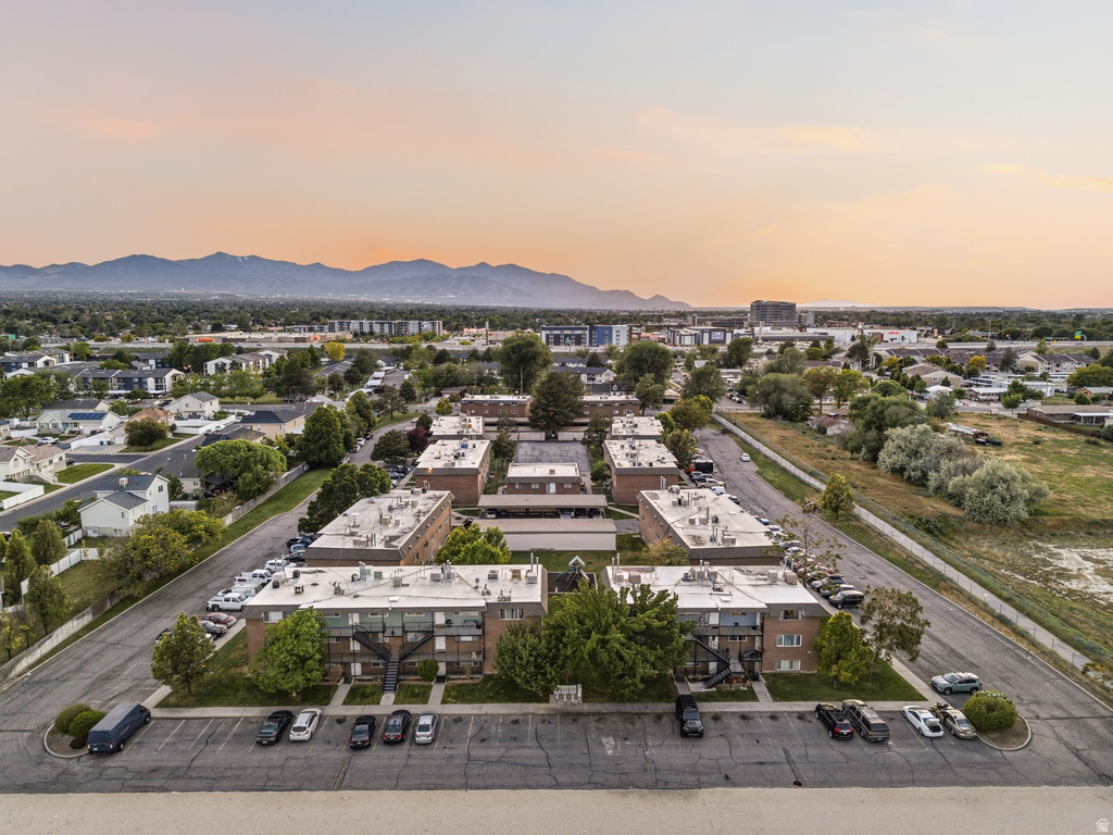Aerial perspective of a multi-building property featuring brick and light-colored siding exteriors, extensive surface parking, and mature landscaping