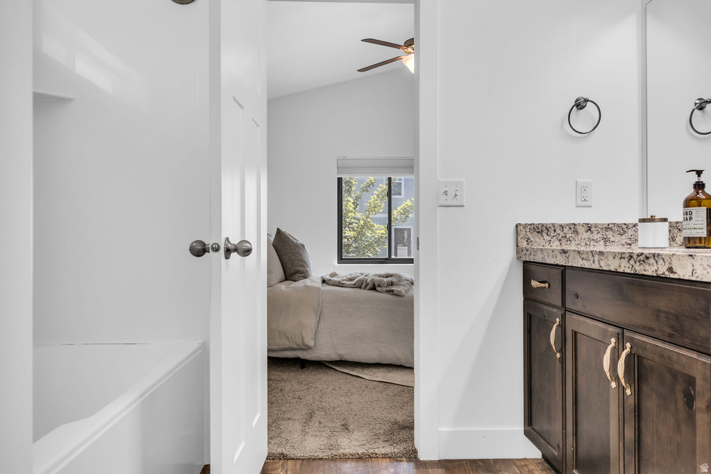 Bathroom vanity with a stone countertop and dark wood-finish cabinetry