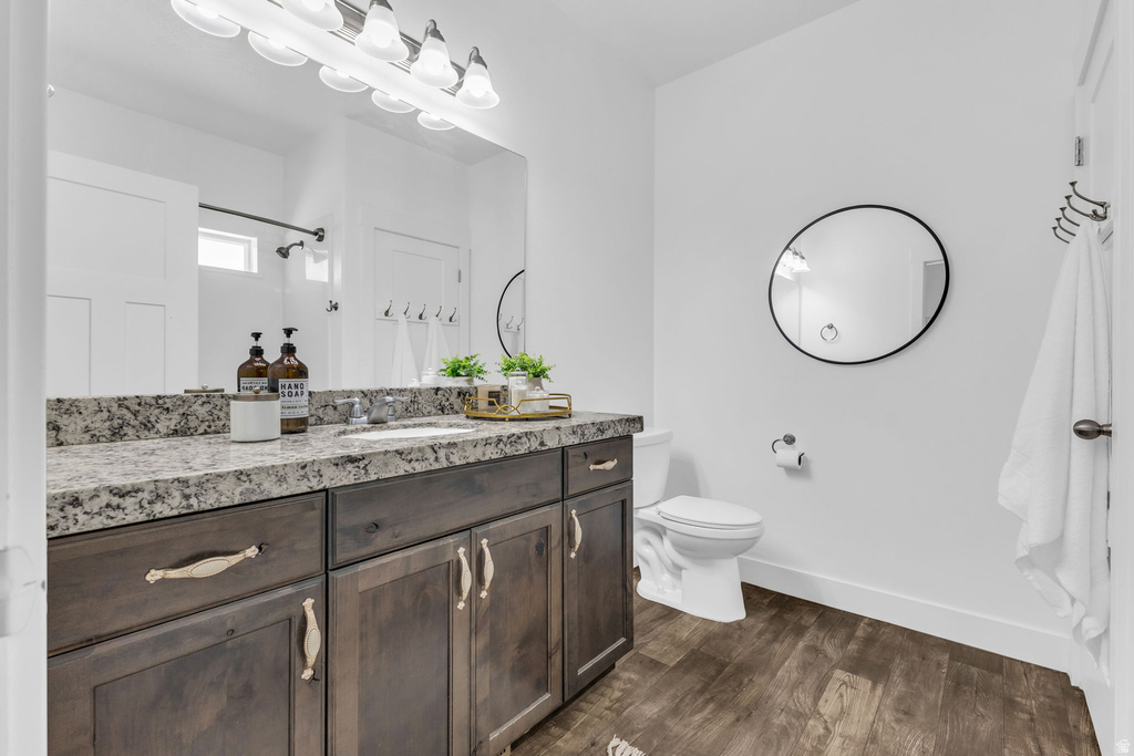 Bathroom featuring a dark wood-finish vanity with a light granite countertop and undermount sink