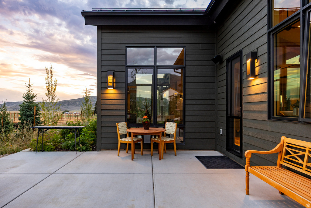 Exterior patio with a concrete surface, featuring a modern dark-toned siding facade