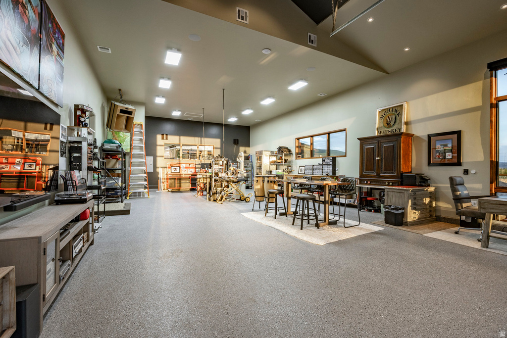 Spacious interior room featuring durable epoxy flooring, recessed lighting, and large windows