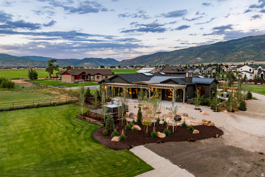 Expansive property featuring a modern architectural residence with a covered patio, extensive landscaping, and a broad lawn