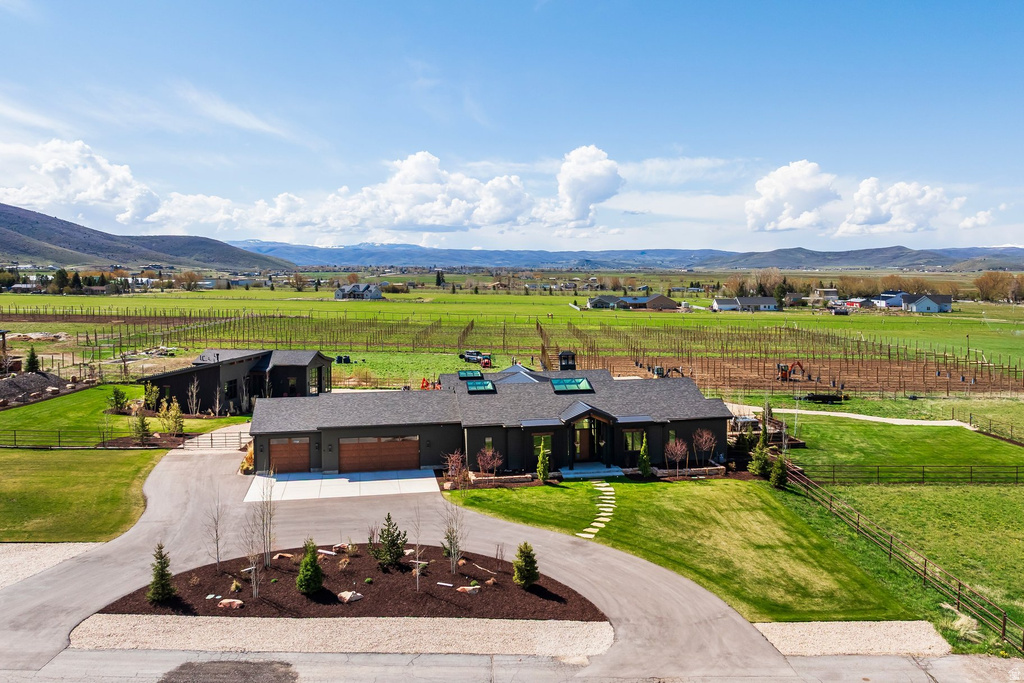 Contemporary ranch-style residence featuring a dark-toned exterior, multiple skylights, and a stone walkway