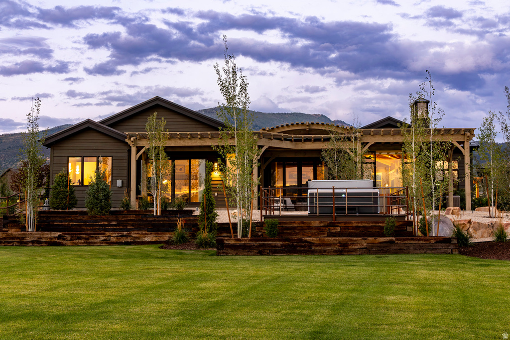 Expansive backyard featuring a manicured lawn and a multi-level terraced landscape with mature trees