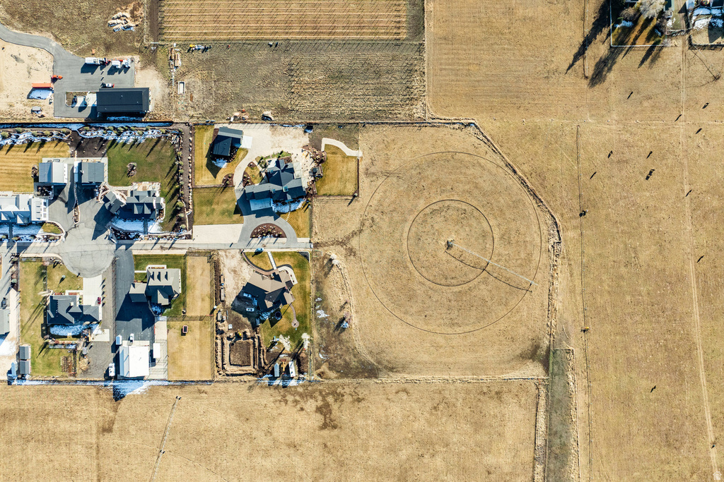 Expansive property featuring a circular field, large residential structures, manicured lawns, and substantial undeveloped land