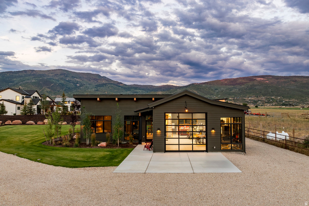 Contemporary exterior with dark siding and a prominent glass paneled garage door