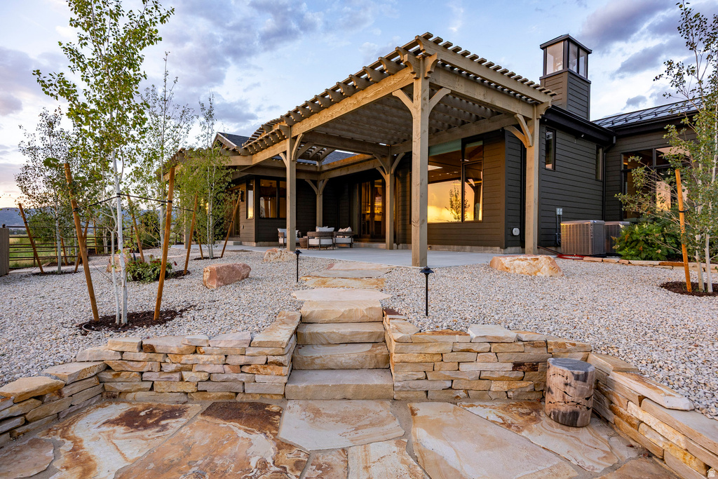 Expansive outdoor living area featuring a wood pergola and a spacious stone patio