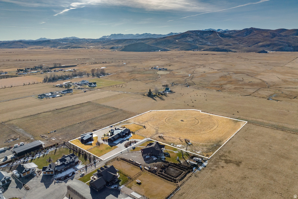 Expansive property featuring a primary residence, a secondary structure, and substantial undeveloped land framed by a white outline